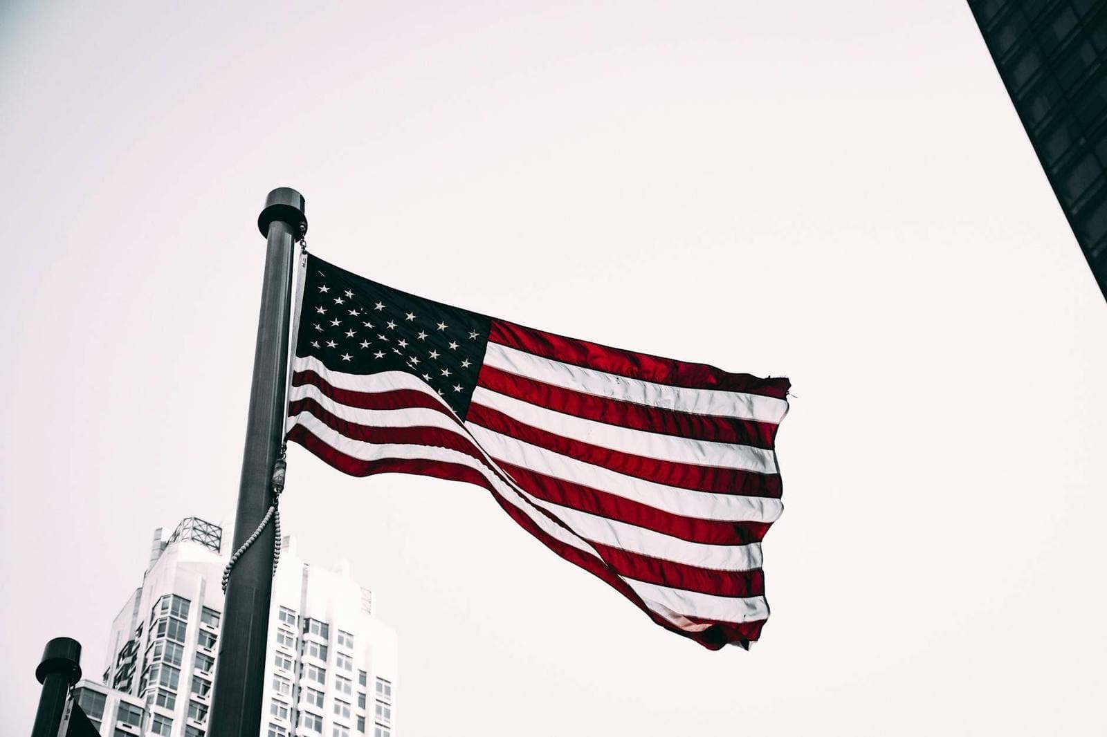 American flag waving with city skyline in the background